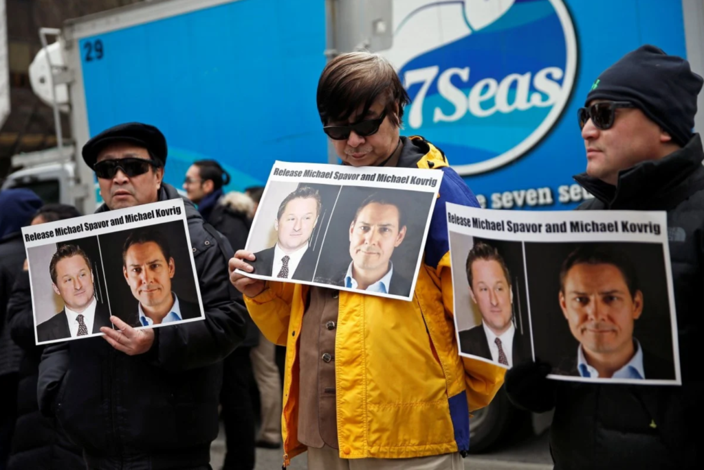 People hold placards calling for China to release Canadian detainees Michael Spavor and Michael Kovrig: SCMP via Reuters
